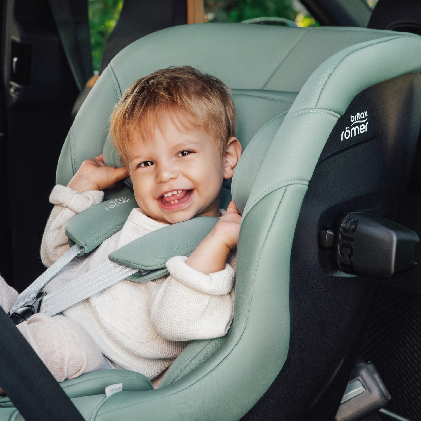 Bambino sorridente assicurato nel seggiolino auto MAX-SAFE PRO in Jade Green.